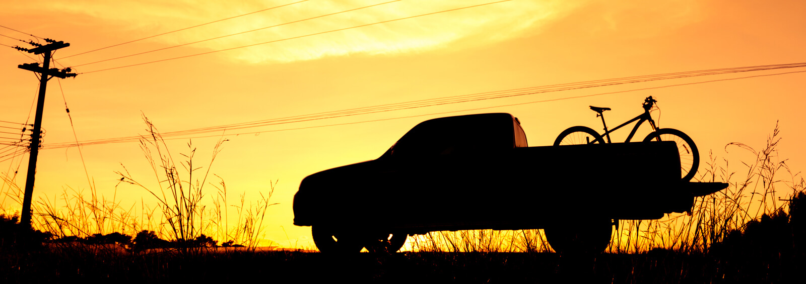 Silhouette Pickup Truck With Bicycle At Sunset Sky